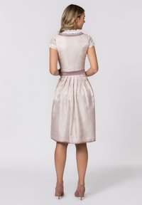 Ein hellrosa Kleid mit einem taillierten Oberteil, Spitzenärmelchen und einem plissierten Rock, akzentuiert durch einen Satinbund. Glatte Textur.