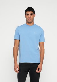 Ανοιχτό μπλε βαμβακερό T-shirt με στρογγυλή λαιμόκοψη και κοντά μανίκια, με μαύρο λογότυπο "BOSS" στο αριστερό μέρος του στήθους.