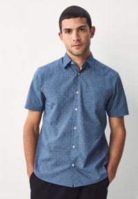 Koszula z krótkim rękawem na guziki w ciemnoniebieskim kolorze, z delikatnym białym wzorem, kołnierzykiem i standardowym krojem. Gładkie wykończenie tkaniny.