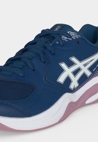 Μπλε αθλητικό παπούτσι ASICS με λευκό λογότυπο, ροζ και λευκή σόλα και σκούρα μπλε κορδόνια, γωνιακό για να δείξει πλευρικές και εμπρόσθιες λεπτομέρειες.