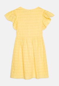Żółta bawełniana sukienka z falującymi rękawami, marszczonym pasem i teksturowanym wzorem. Posiada zamek błyskawiczny z tyłu i długość do kolan.