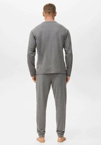 Top de manga larga gris y pantalones a juego, hechos de una tela suave. El top tiene un cuello redondo, mientras que los pantalones tienen un ajuste relajado.