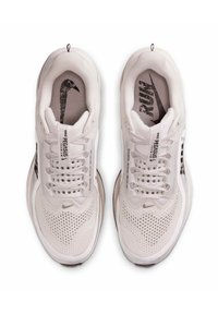 Par af hvide Nike Pegasus løbesko med åndbare mesh-overdele, hvide snørebånd og sorte Nike-logoer på indersåler og tunger.
