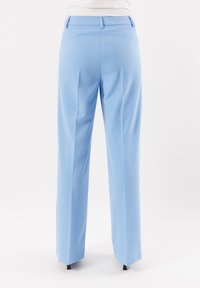 Pantaloni azzurri chiari con vestibilità dritta, realizzati in tessuto morbido. Presentano un girovita con passanti per la cintura e due tasche posteriori.