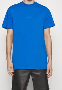 Modrá bavlněná trička s kulatým výstřihem, krátkými rukávy a malým potiskem "424" v kontrastní barvě na hrudi.