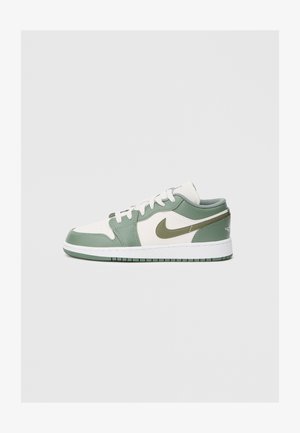 Nike alacsony szárú sneaker, fehér bőr felsőrésszel, világoszöld részletekkel és texturált díszítéssel. Gumitalp, mintázott profilú.