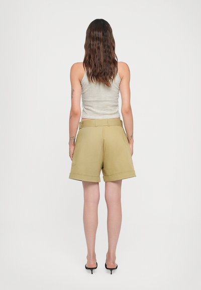 Khaki-Bermuda-Shorts mit umgeschlagenem Saum, mit Gürtelschlaufen und Seitentaschen, kombiniert mit einem gestreiften ärmellosen Oberteil.