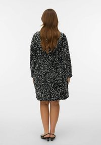 Crna haljina sa sequinama, slobodnog kroja, dugim rukavima i okruglim izrezom, s teksturiranom, sjajnom površinom i dužinom do sredine butina.