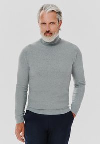 Szary sweter z golfem wykonany z miękkiej, dzianinowej tkaniny. Posiada długie rękawy i dopasowany krój. Zestawiony z ciemnymi spodniami o prostym fasonie.