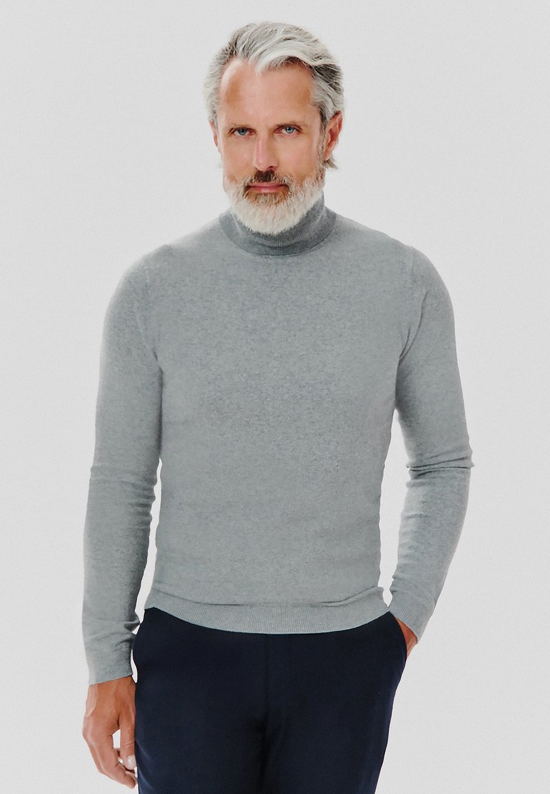 Szary sweter z golfem wykonany z miękkiej, dzianinowej tkaniny. Posiada długie rękawy i dopasowany krój. Zestawiony z ciemnymi spodniami o prostym fasonie.