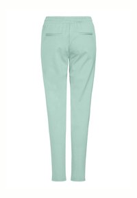 Ljusgröna joggerbyxor med elastisk midja, avsmalnande ben och två bakfickor. Slät textur, avslappnad design, inga synliga knäppningar.