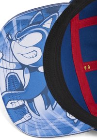 Blå kasket med en tegneseriefigur på den indvendige skygge. Materialet er stof; designet inkluderer sort kant og røde accenter.