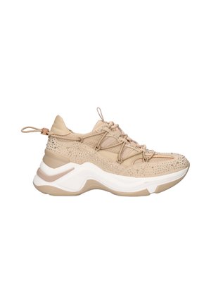 Zapatillas beige con un upper texturizado, que presenta tachuelas decorativas, un cuello acolchado y una suela blanca gruesa con acentos sutiles.
