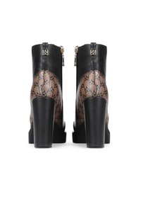 Botines de tacón alto negros con parte superior de cuero texturizado y un panel transparente con patrón. Incluyen cremalleras con acentos metálicos.