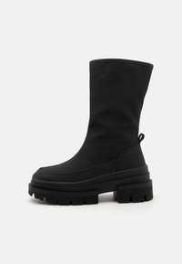 Black ankle boots with a smooth canvas upper, thick rubber soles, and a rounded toe. Features a pull tab at the back for easy wear.