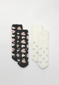 Due paia di calze pelose: una nera con cuori rosa e bianchi, l'altra bianca con cuori grigi. Tessuto morbido e design della punta arrotondata.