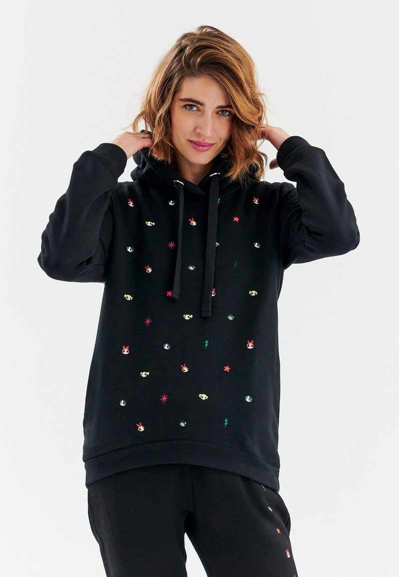 Černá mikina s kapucí s barevnými vyšívanými vzory, včetně očí, hvězd a blesků. Obsahuje stažení kapuce a volný střih.