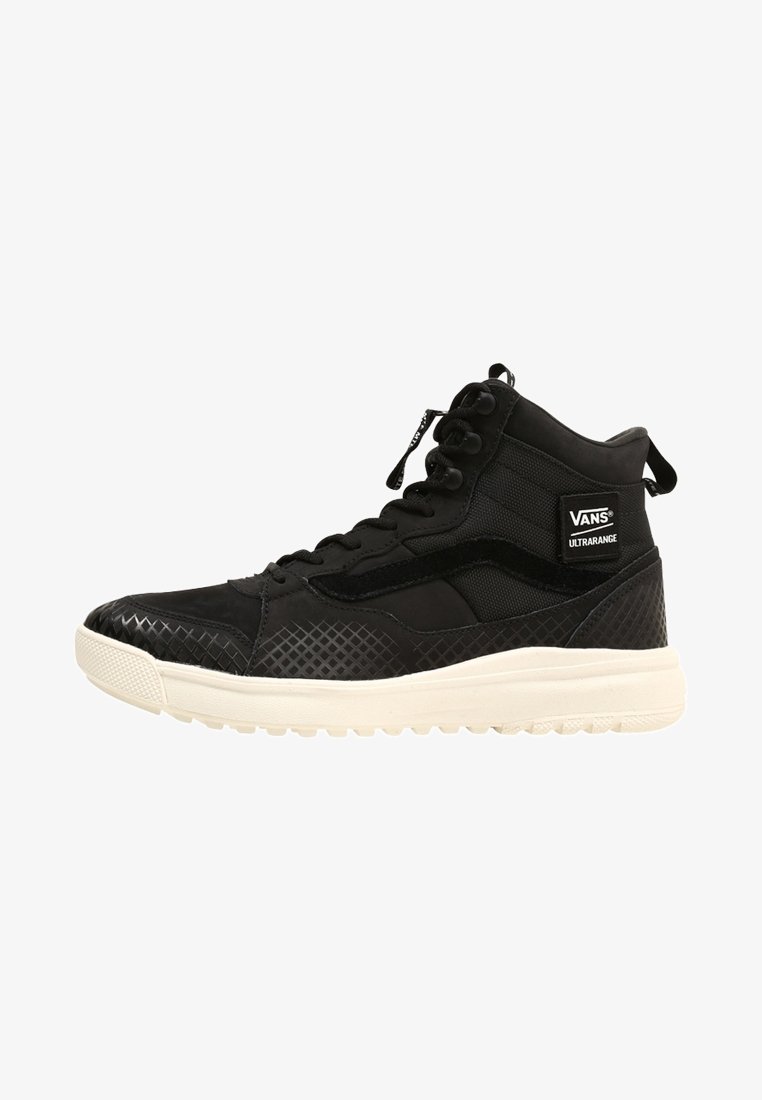 Baskets montantes noires en matériaux mixtes, avec un panneau texturé à motif losange et une semelle en caoutchouc blanche. Marque VANS visible.