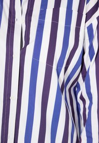 Pruhovaná košile v bílé, fialové a modré barvě. Má přední kapsu, knoflíkové zapínání a lehkou texturu látky.