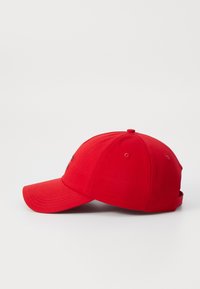 Röd bomullsbasketkeps med en böjd skärm, enfärgad design, justerbar rem bak, med logodetaljer på framsidan.