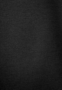 Black textured fabric with a fine weave, showing a uniform pattern. Material appears soft and matte without any visible shine or embellishments.