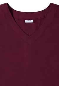 T-shirt col en V bordeaux avec des coutures visibles au niveau du col et une étiquette blanche indiquant "CECIL" à l'arrière de l'encolure intérieure.