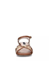 Sandal marrone con una tracolla intrecciata testurizzata, fibbia regolabile alla caviglia e una soletta liscia di un leggero beige. Punta arrotondata e suola durevole.