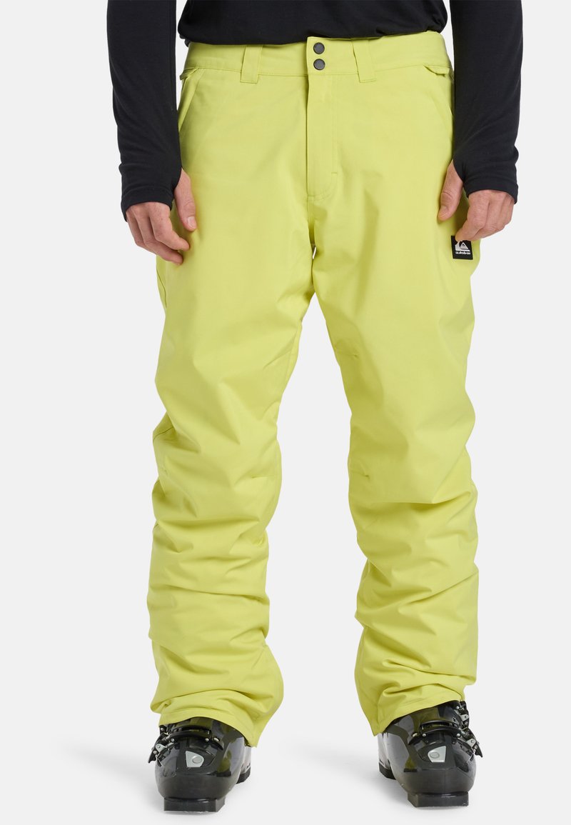 Felgeel sneeuwbroek met een losse pasvorm, gemaakt van waterdicht materiaal, met een ritssluiting en drukknoopsluiting en zijzakken.