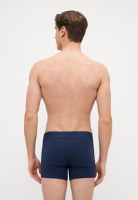 Boxeri navy dintr-un material neted, cu un waistband confortabil și un design ajustat, prezentați din spate pe un fundal curat.