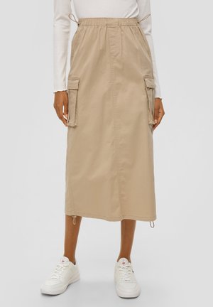 Beige midi skirt with drawstring waistband, side cargo pockets, and adjustable hems, made of lightweight fabric, paired with white sneakers.