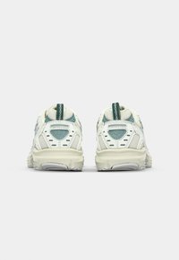 Zapatillas de running en blanco y azul claro, con material de malla, suela acolchada y una lengüeta en el talón para facilitar su uso.