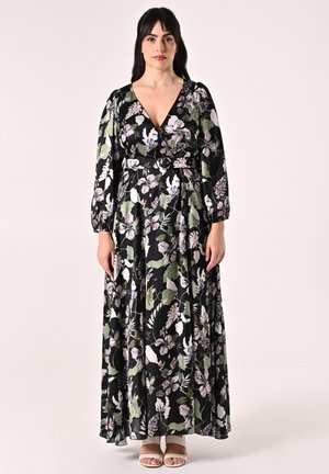 Robe maxi noire avec imprimé floral vert et violet. Elle présente de longues manches bouffantes, un décolleté en V et une taille cintrée. Texture de tissu lisse.