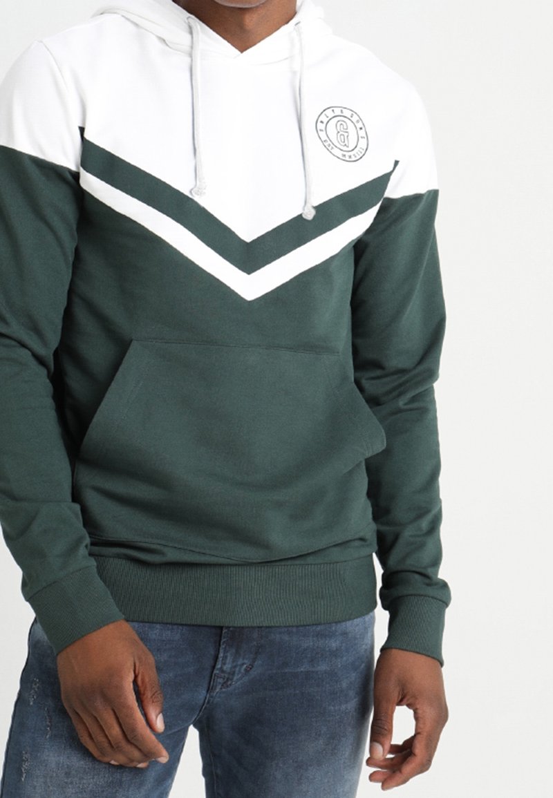 Sudadera verde oscuro con diseño de chevron blanco, bolsillo frontal, capucha con cordón y logo. Fabricada con un tejido suave y texturizado.