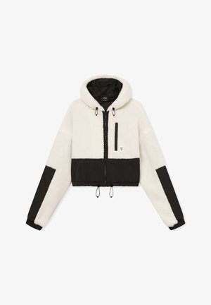 Cropped hoodie in cream and black. Made of plush fleece with a zip closure, adjustable drawstrings, and a chest pocket. Features elastic cuffs.