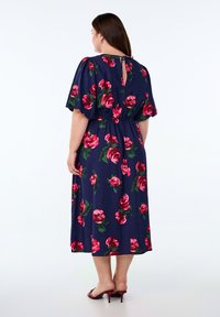 Navy blauwe jurk met bloemenrozenpatroon, korte pofmouwen, elastische taille en een keyhole-opening achter. Gestructureerde stof met een zachte textuur.