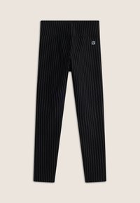 Leggings negros con rayas verticales blancas, cinturilla elástica y una pequeña etiqueta de logo. Material suave y elástico, diseño ceñido.