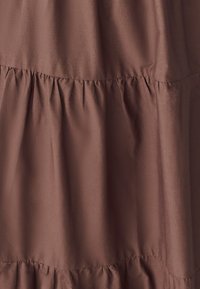 Rudas audinio daugiapakopis suknelė, su lygiu paviršiumi ir surinktomis siūlėmis, su pūkuota apatine dalimi.