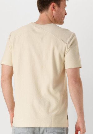Korte mouw beige t-shirt van een textuurstof, met een ronde halslijn en een logodetail op de bovenrug. Eenvoudig en casual ontwerp.