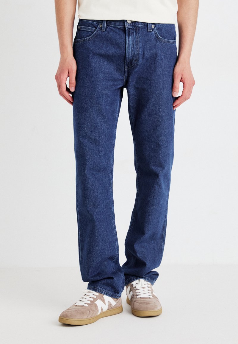 Mørkeblå denim jeans med en klassisk rette bein-design. Egenskaper inkluderer fem lommer, knappelukking og subtile sømdetaljer.