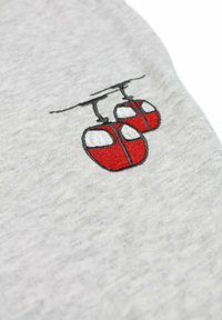 Tissu gris avec un motif brodé de deux gondoles rouges aux contours noirs et un câble au-dessus, créant une composition équilibrée.