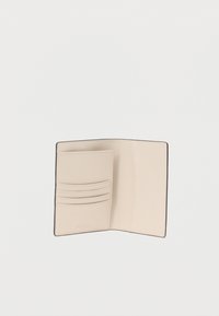 Μπεζ δερμάτινο πορτοφόλι με τέσσερις θήκες για κάρτες και απαλή υφή. Διαθέτει απλό σχέδιο και διακριτικό σήμα στο εσωτερικό. Οι άκρες είναι ραμμένες.