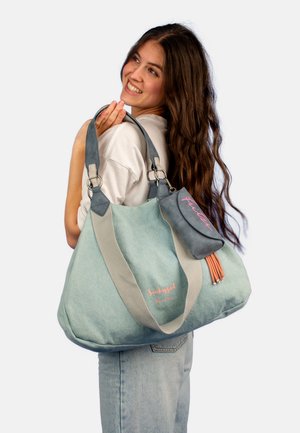 Mintgroene stoffen draagtas met grijze accenten en een roze geborduurd logo. Bevat dubbele handvatten en een klein bijgevoegd tasje met franjes.