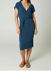 Vestido envolvente teal con mangas cortas, tejido texturizado, cinturón autoadherente en la cintura, hasta la rodilla y una abertura en el dobladillo. Estilo casual.