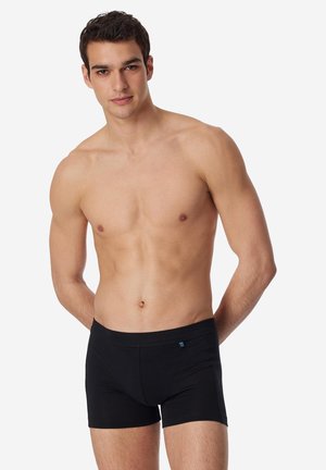 Sorte boksershorts lavet af blødt stof, der har en tætsiddende pasform og en bred linning. Enkel design med et logo på forsiden.