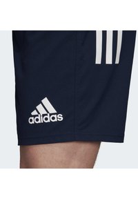 Marineblaue Sportshorts mit weißem Adidas-Logo und drei weißen Streifenakzenten. Hergestellt aus leichtem, atmungsaktivem Stoff mit einer glatten Textur.