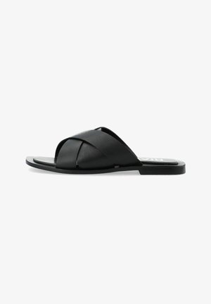 Sandali infradito in pelle nera con cinghie incrociate, suola piatta e soletta testurizzata. Design semplice con un'estetica minimalista.