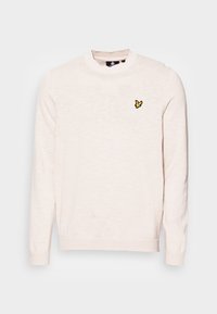 Pull léger rose pâle à col rond en tissu doux, avec un petit logo brodé jaune sur la poitrine et des poignets côtelés.