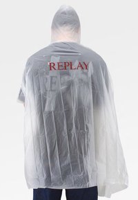 Prozirni kišni pončo s kapuljačom, siva boja tijela i crveni natpis "REPLAY" na leđima. Izrađeno od laganog, naboranog plastičnog materijala.
