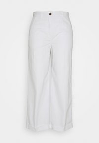 Un pantalon large taille haute blanc avec une fermeture à bouton et des ourlets repliés, suspendu sur un fond blanc.