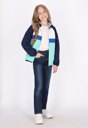 Letvægts zip-up jakke med navy, teal og hvide farveblokke. Sammen med mørkeblå denim jeans og hvide sneakers. Glat tekstur.